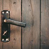 A door handle with a key on a wooden door