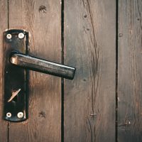 Door handle with a key on a wooden door A door handle with a key on a wooden door